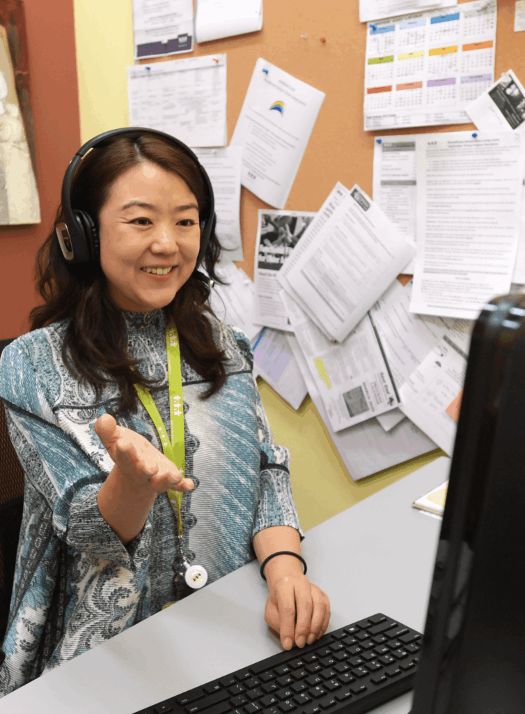 A WoodGreen worker answering a call at her desk in front of her computer