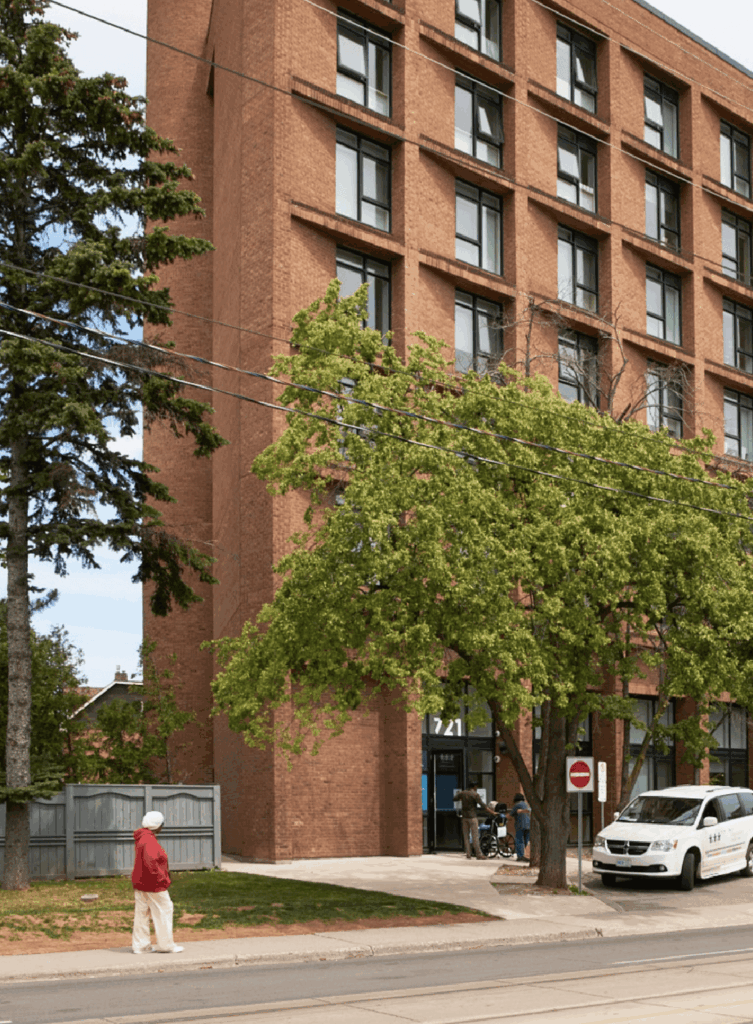 Person walking outside a WoodGreen building in the daytime