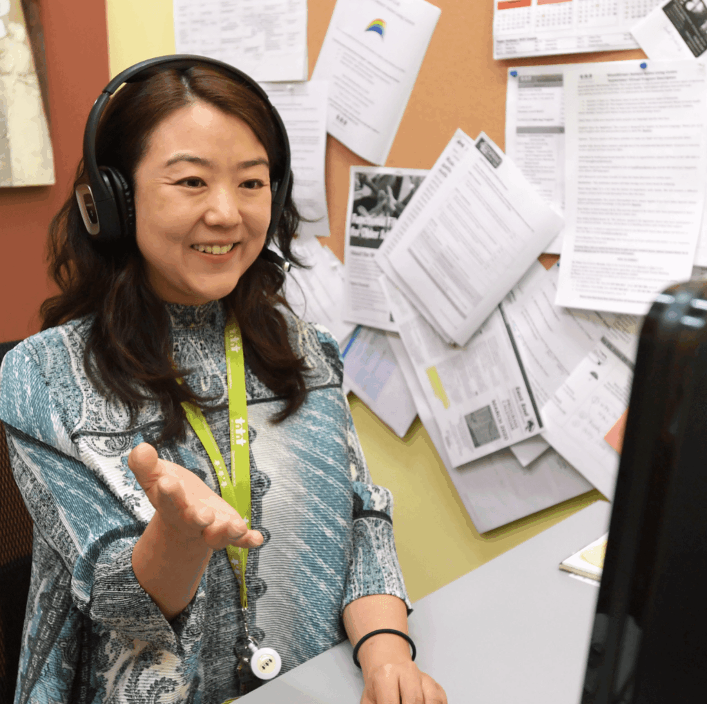 A WoodGreen worker answering a call at her desk in front of her computer