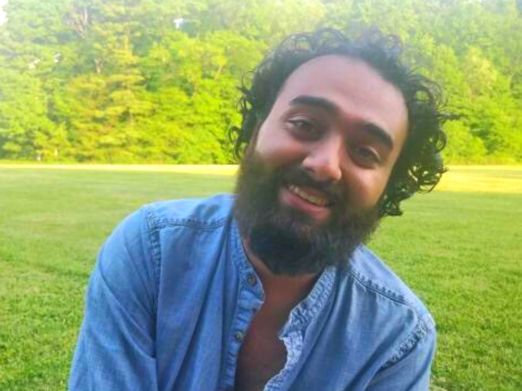 Frontline worker Vishaal Beharry in an open green field.