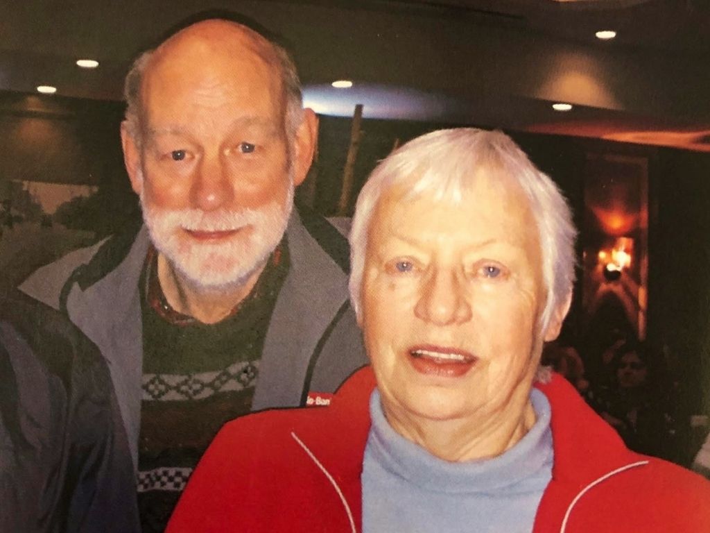 A man in a grey jacket and a woman in a red fleece jacket