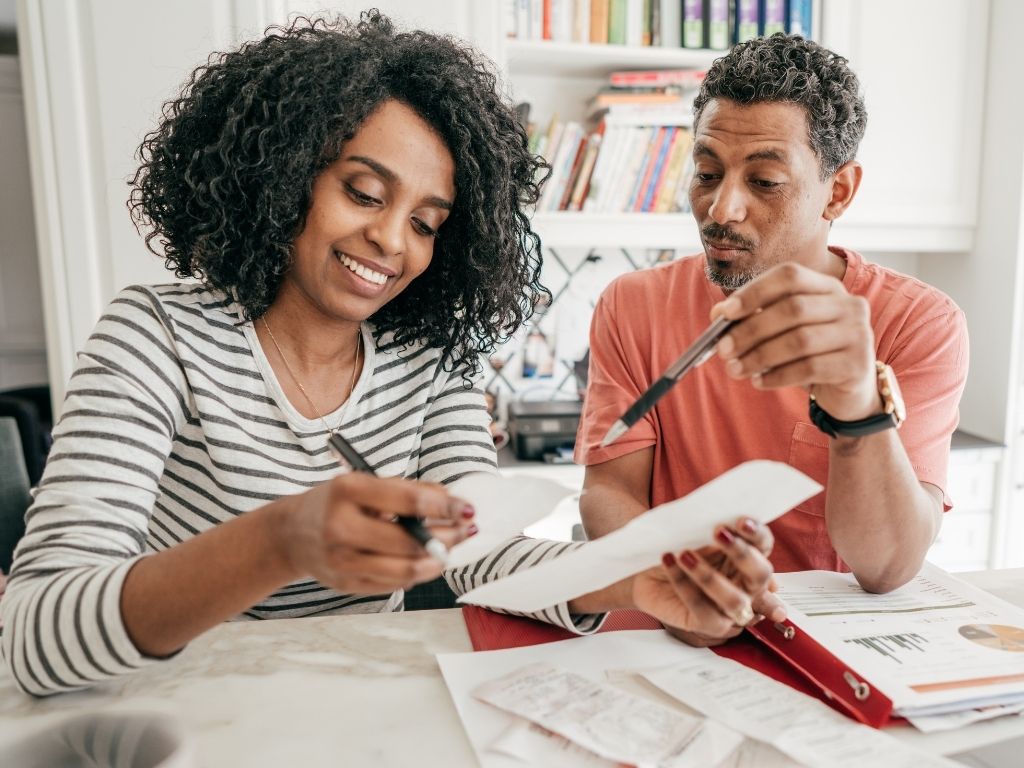 Man and woman work together to complete tax forms