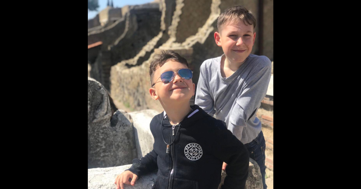 Two young boys, Serge and Vlad Cobchuk, pose on a rock in Ukraine