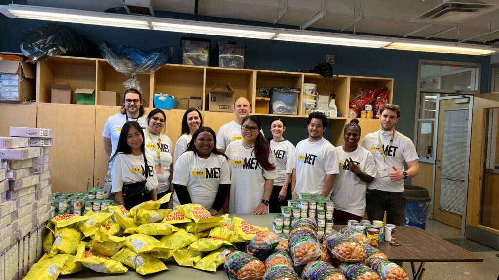 Staff and volunteers in UNMET t-shirts with food donations