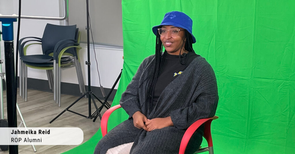 a young Black woman being interviewed in front of a green screen