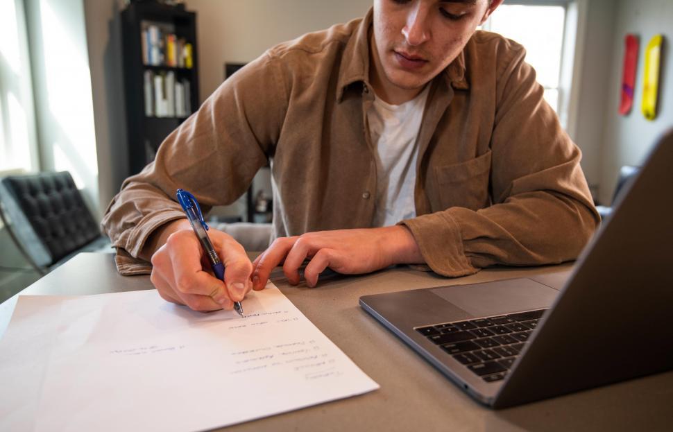 Person writing on paper at a desk 