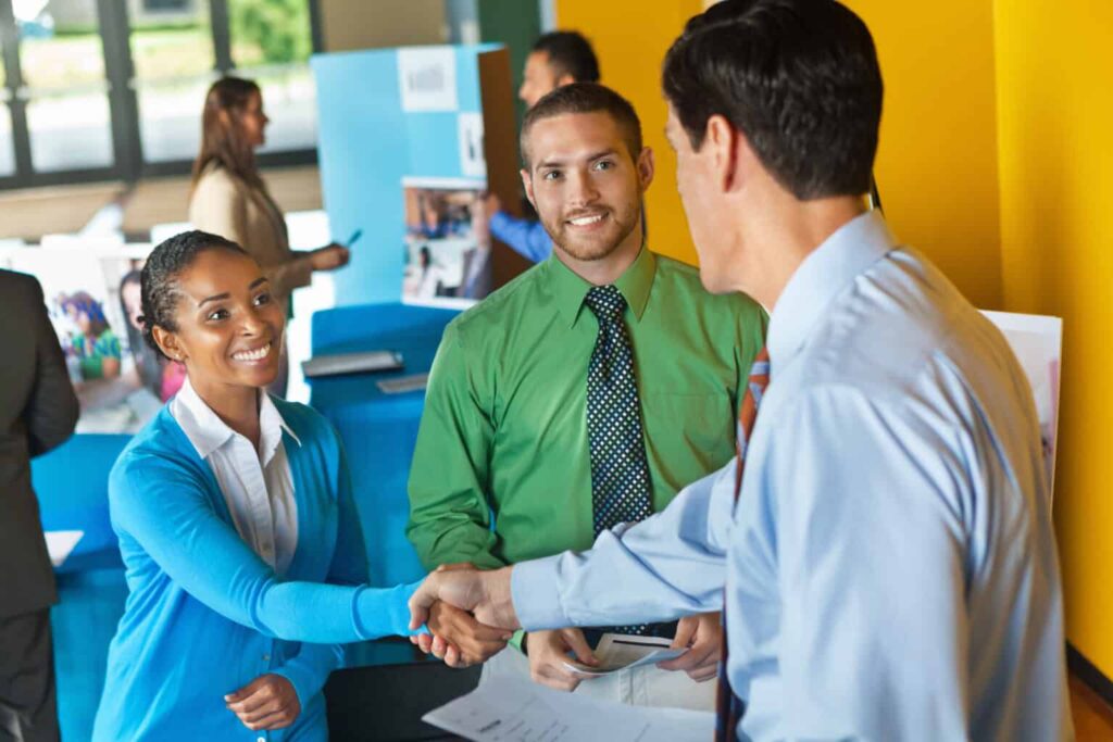 Person attending a job fair and shaking hands with employer